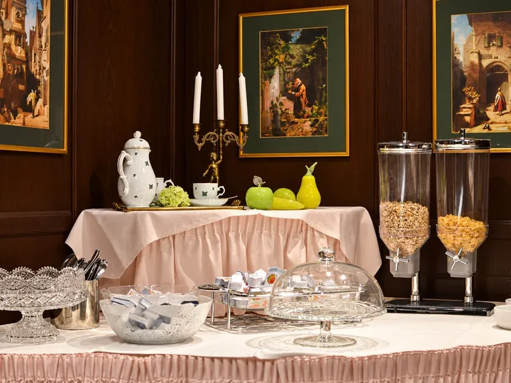 Frühstücksbuffet mit Porzellan, Kerzenleuchter und Gemälden