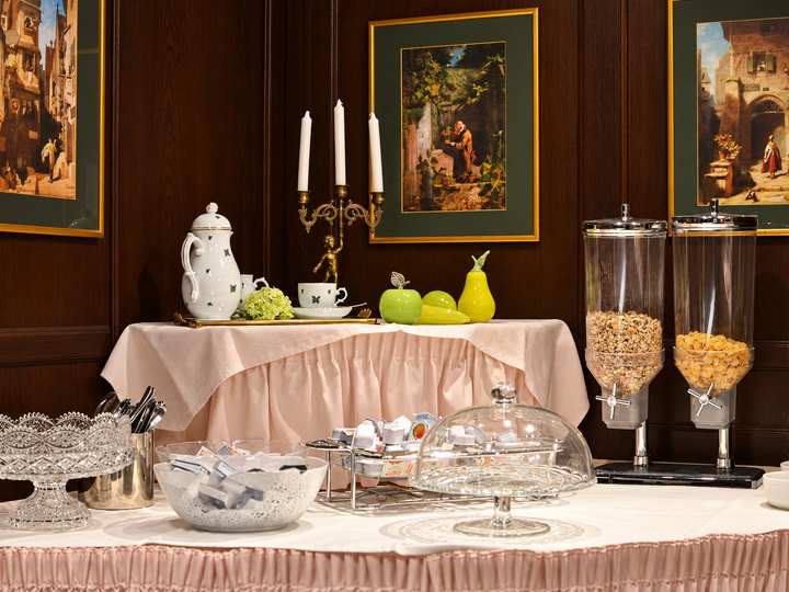 Frühstücksbuffet mit Porzellan, Kerzenleuchter und Gemälden